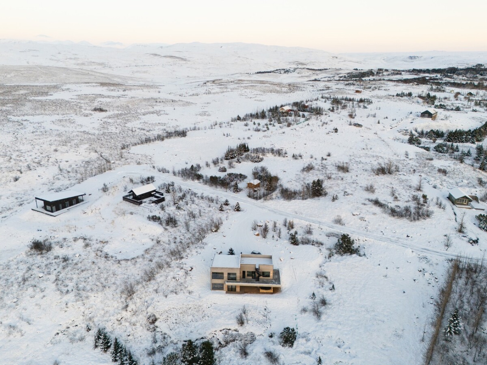 The house from the air in winter, alone on the white ridge